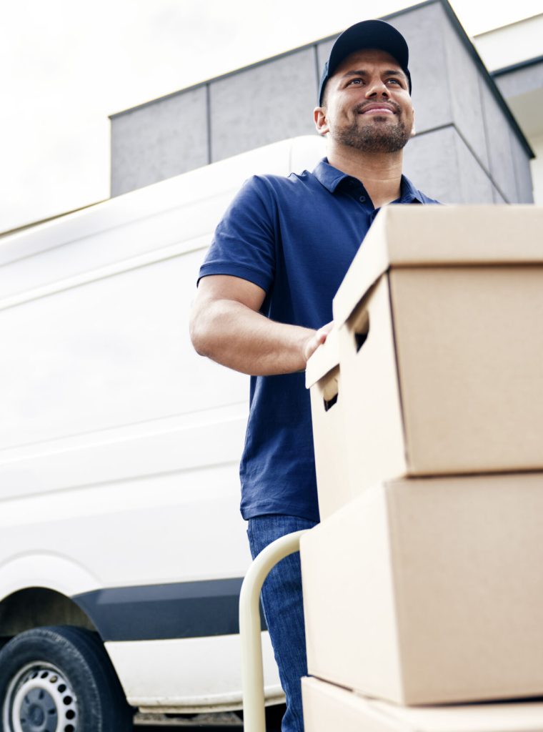Delivery driver moving parcels on hand truck