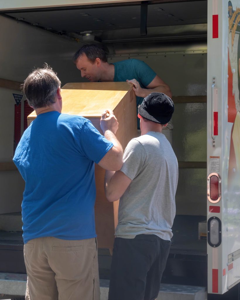 Family helping load furniture onto the truck on moving day
